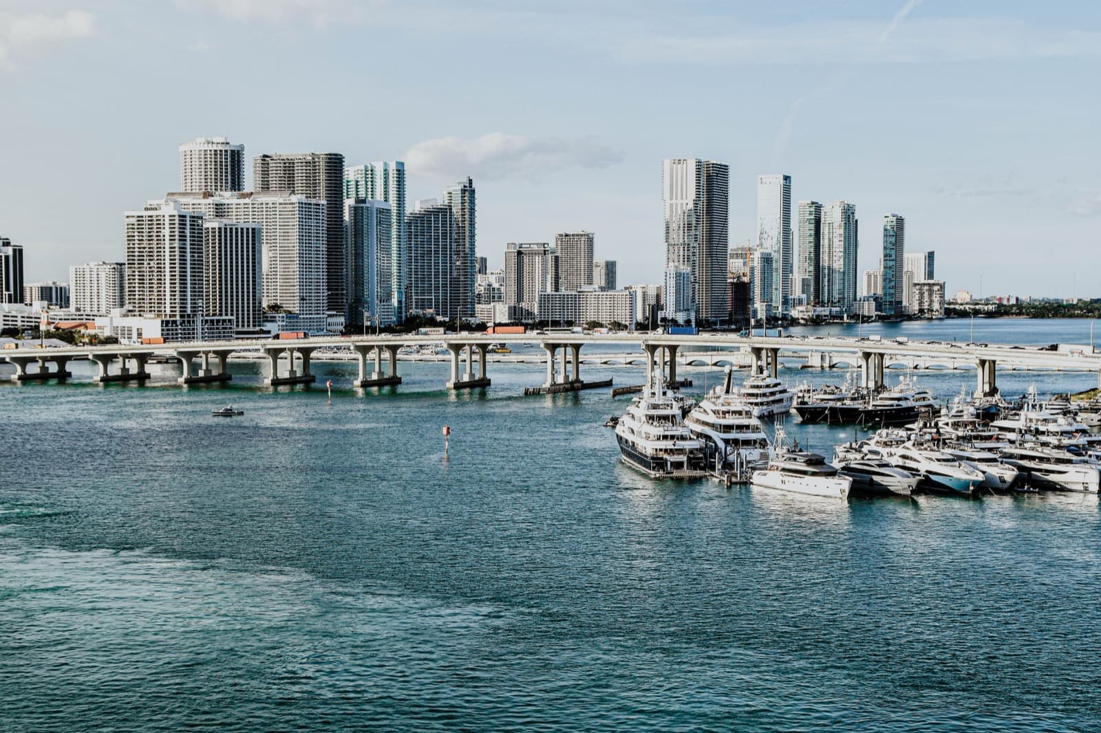 Yachts moored in a Miami marina with the downtown skyline behind