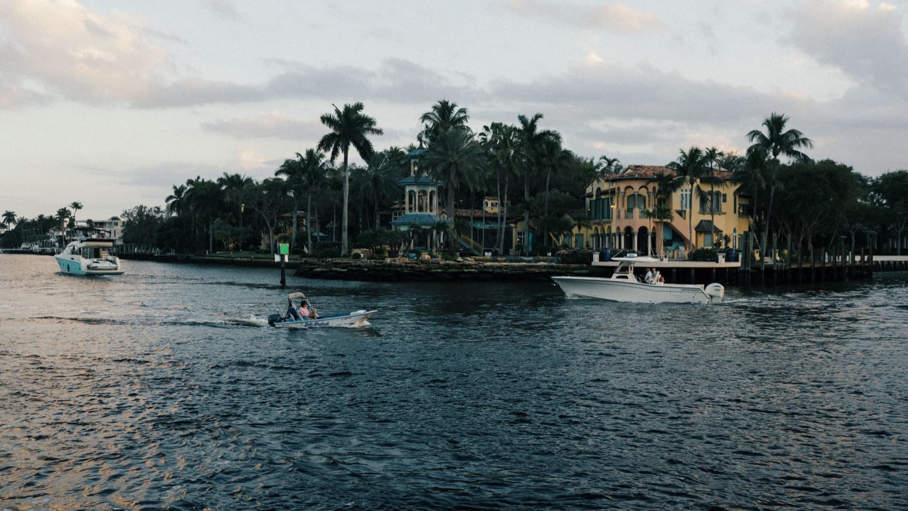 Waterfront homes with private docks on the Intracoastal at dusk, boats passing